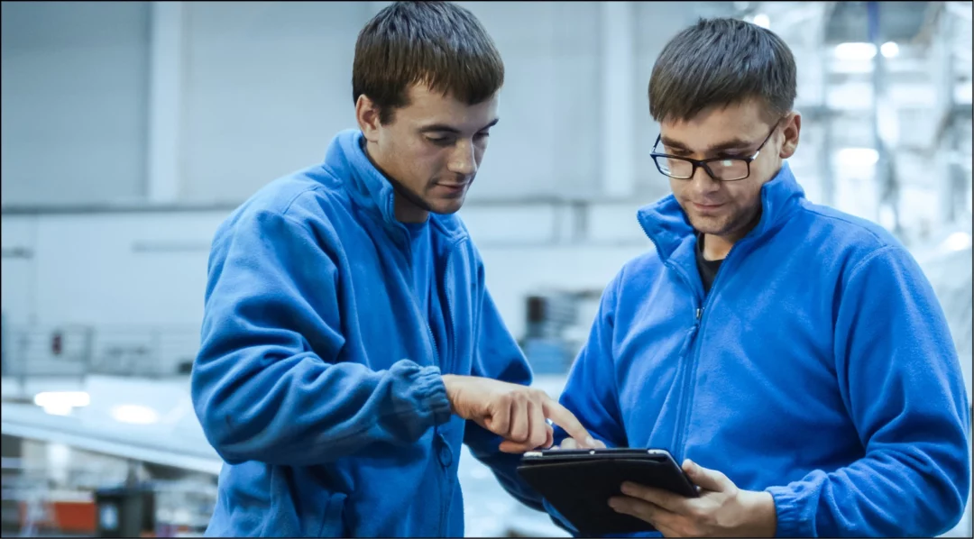 Workers use a tablet for mobile inspections to improve production performance.