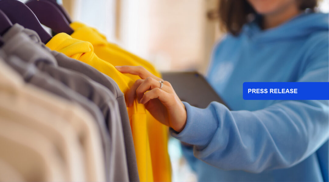 Woman inspecting yellow garment on rack, SAP.iO Foundry New York