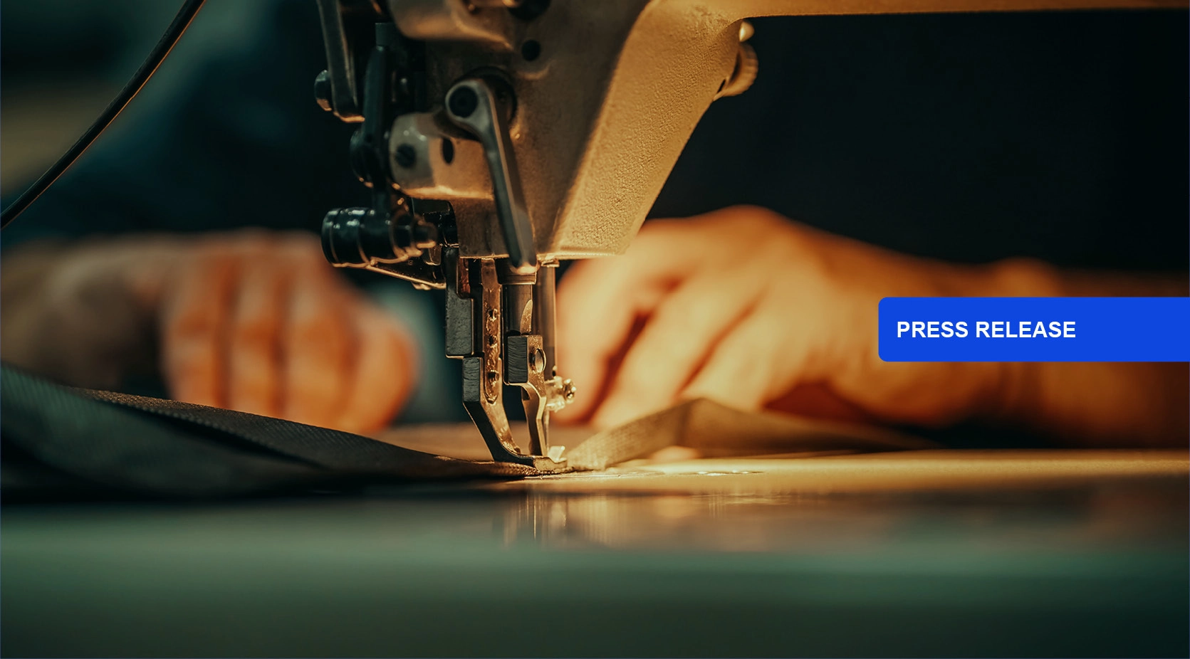 Close-up of a sewing machine needle stitching fabric, with "PRESS RELEASE" button