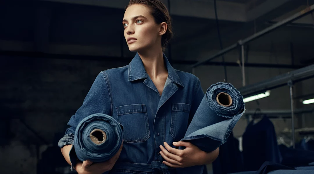 US apparel retailer model holds denim rolls in factory