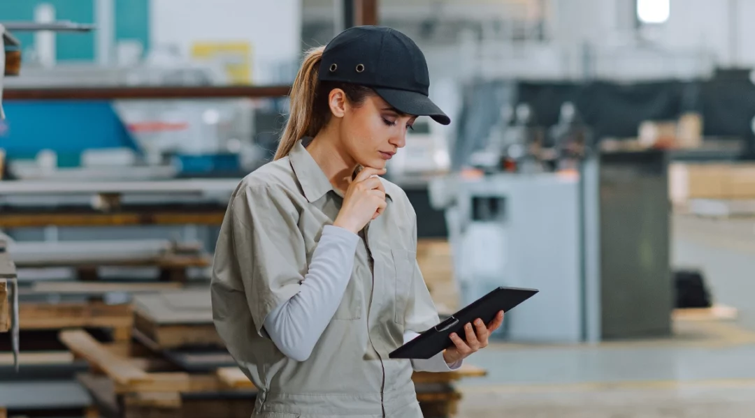 Woman in workwear using tablet for supply chain management