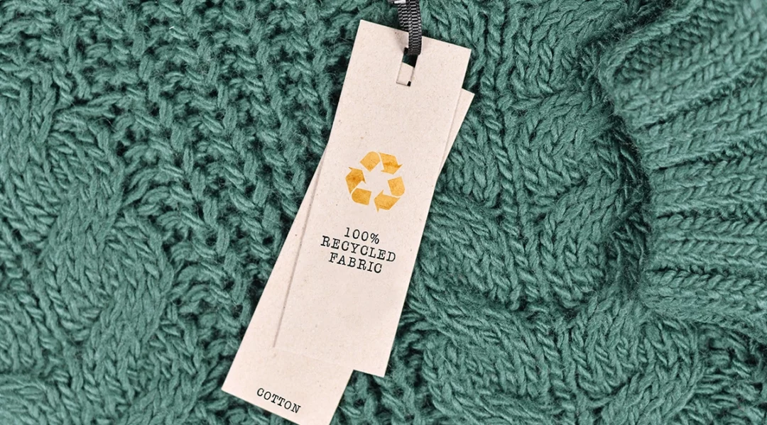 Recycled fabric tag on green knit sweater, Bill C-59 anti-greenwashing laws