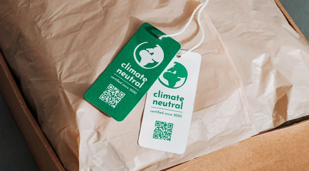 Green and white "climate neutral certified" tags with QR codes