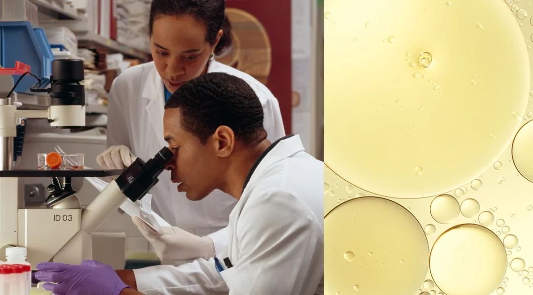 Scientists in lab coats examine samples under a microscope, symbolizing data-driven lab testing.