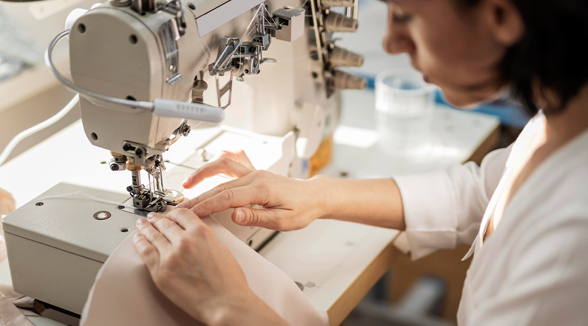 Seamstress operating industrial sewing machine, speeding up garment production.