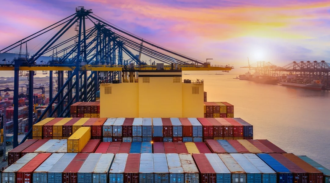 Container ship at port with cranes, symbolizing fashion supply chains in 2026.