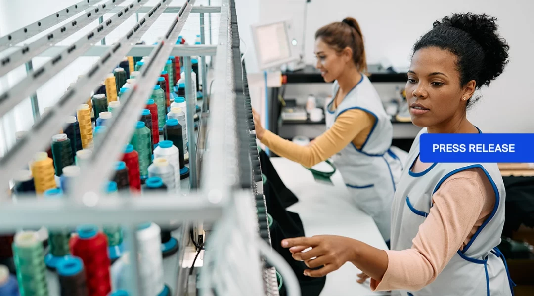 Workers inspect threads in a factory, symbolizing supply chain quality control.