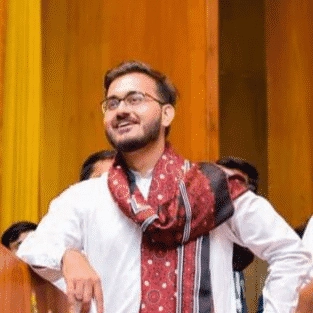 Areeb Ahmed wearing a white kurta and a red and black scarf